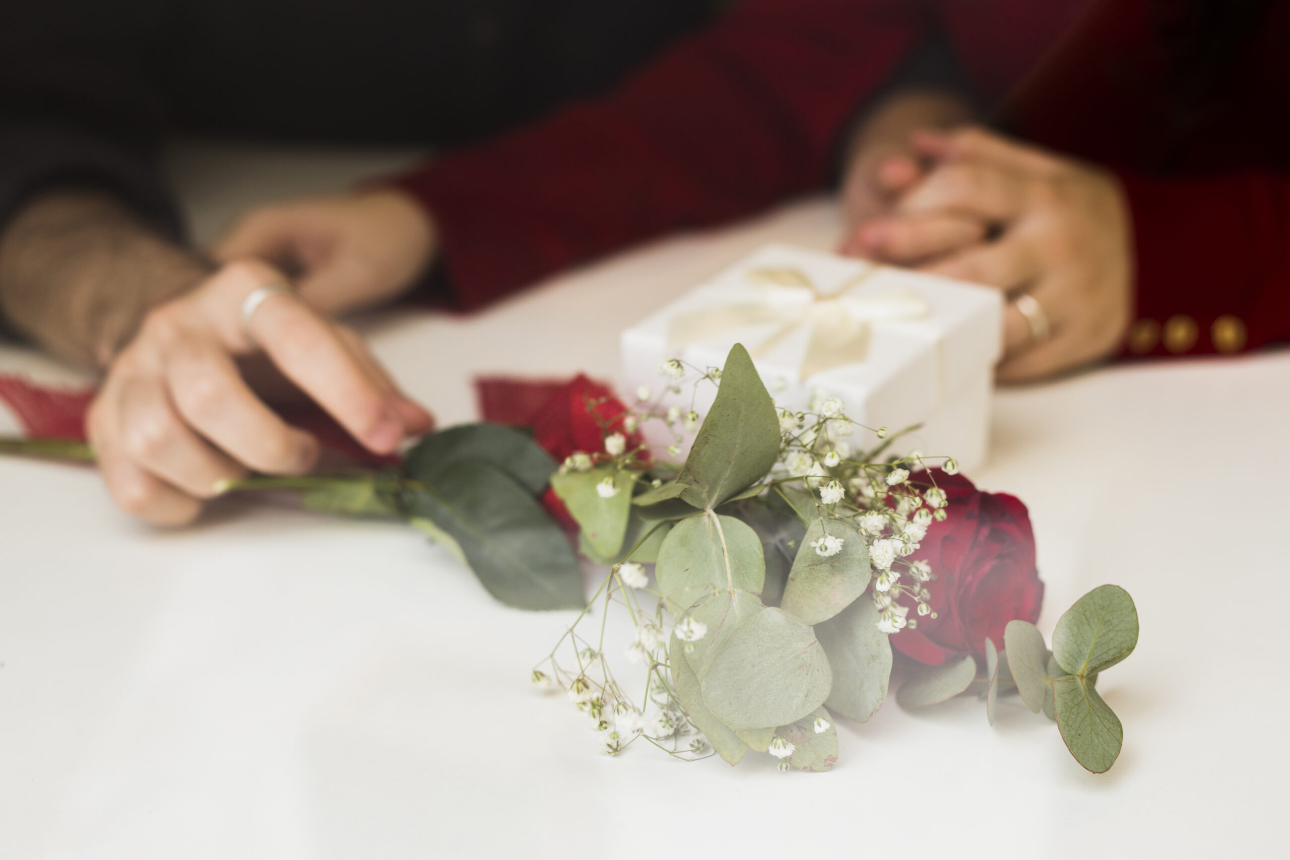 couple-sitting-table-with-rose-gift